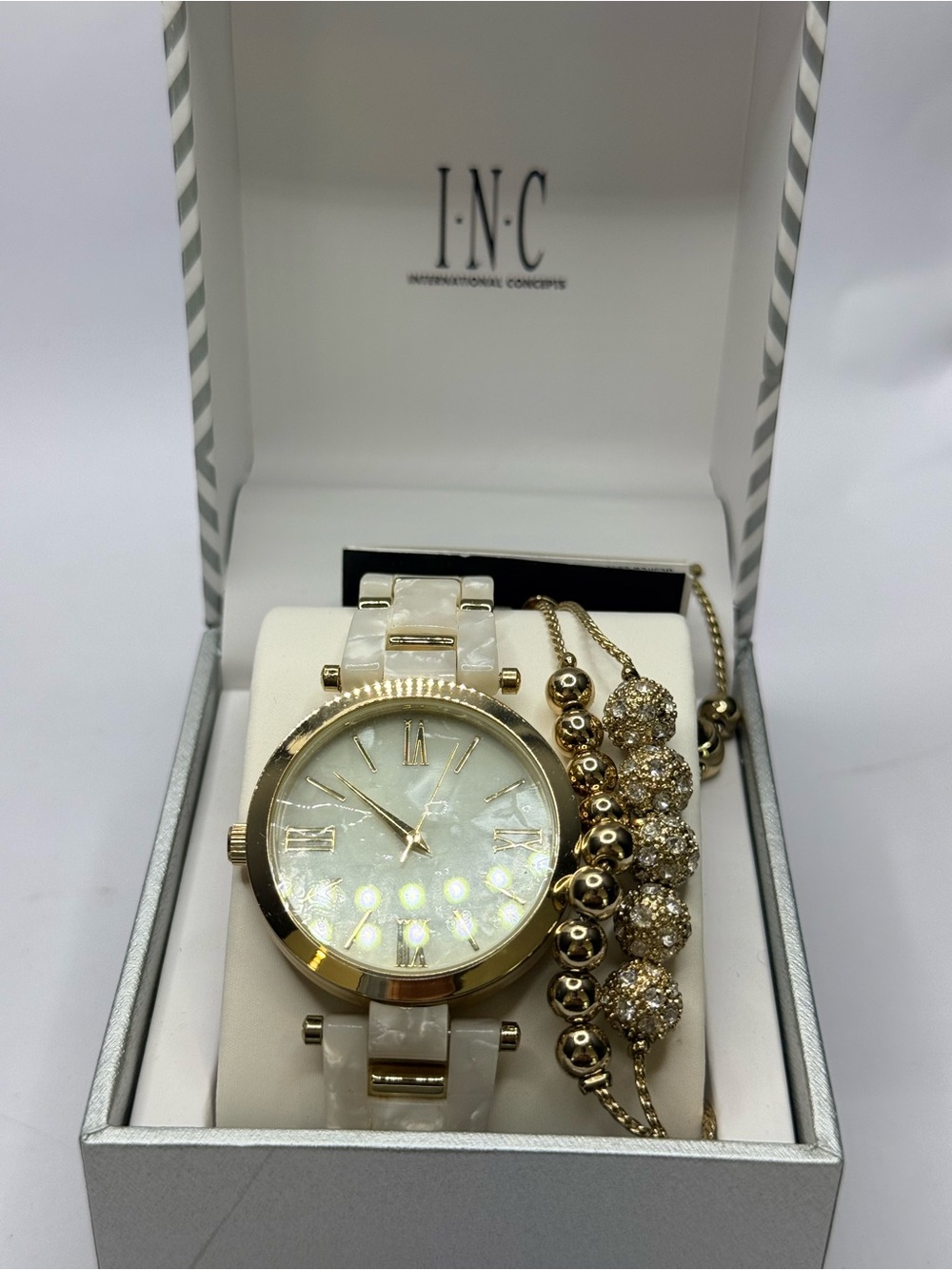INC International Concepts faux mother of pearl watch and gold tone bracelets.